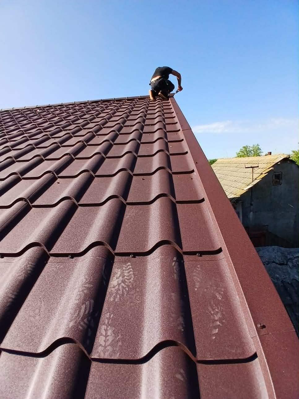 Szakember fémcserép tető szerelése közben